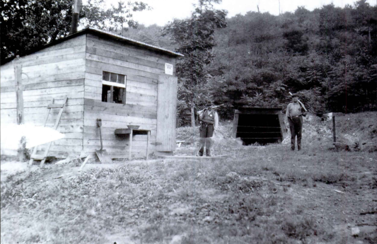 black and white picture of two iron policemen by a shed