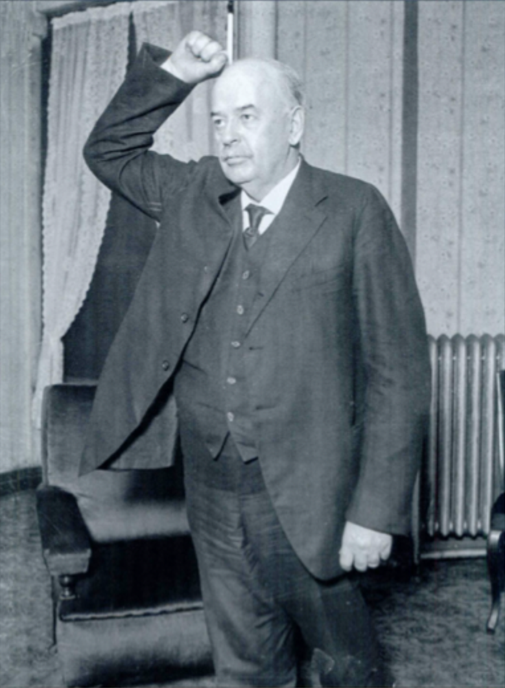 Governor Len Small standing with his fist raised in the air in defiance. 